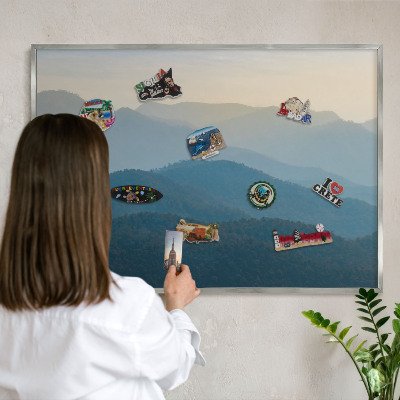 Souvenir magnet display board with a silver frame Mountain views