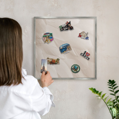 Souvenir magnet display board with a silver frame Cream feathers