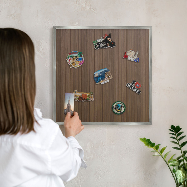 Souvenir magnet display board with a silver frame Wooden background