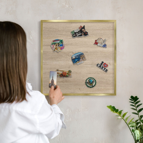 Metal magnet board with a gold frame Wooden background